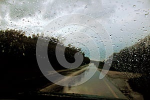 The windshield of the car during the rain is covered with water drops