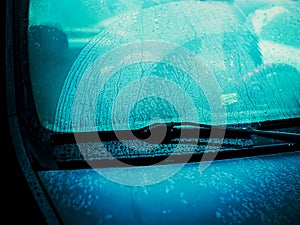 The windshield of a passenger car is covered with drops of rain. Driving in rainy weather. Bad weather