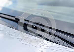 Windshield or windscreen wiper - rain drops on the paint of a car