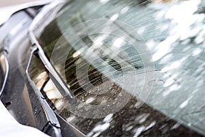 Windshield with wipers of a dirty car.