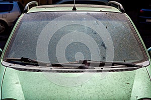 Windshield with wipers dirty car in a layer of dry dirt.