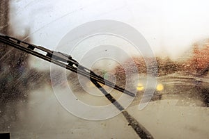 Windshield wipers from inside of car, season rain, front and background blurred with bokeh effect