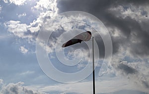 Windsock against cloudy sky