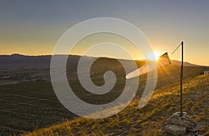 Windsock at sunset in mountains against sun