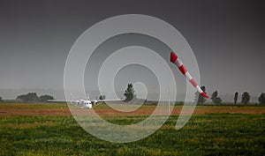 Windsock, weather vane for airfields. Red and white striped fabric showing wind speed, strength and direction. Umbrella cap at the