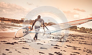 Windsurfer with board on Beach Seaside back view Sea Windsurfing Sport