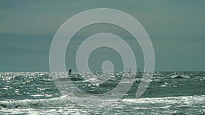 Windsurfer competitions on sea waves in stormy weather