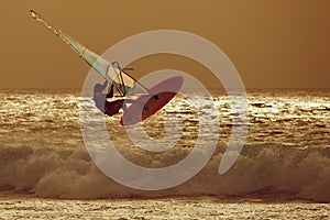 Windsurfer jumping in a sunset sky