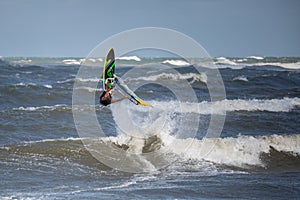 Windsurfer Jumps out of the Water: Stunting on Waves photo
