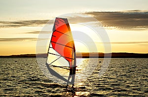 Windsurfer silhouette against a sunset background