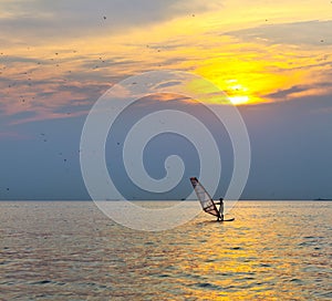 Windsurfer silhouette over sea sunset