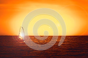 Windsurfer silhouette at sea sunset. Beautiful beach seascape. Summertime watersports activities, vacation and travel photo