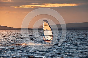 Windsurfer Surfing The Wind On Waves at Sunset