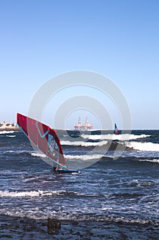 A windsurfer travels on the water