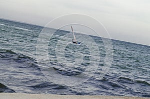 Windsurfers riding waves on a bright cold day