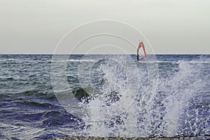 Windsurfers riding waves on a bright cold day