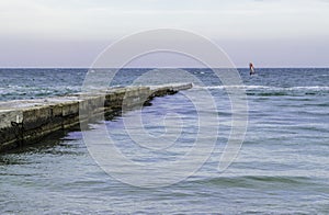 Windsurfers riding waves on a bright cold day