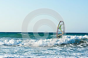 Windsurfers in the sea on Crete on sunset. Windsurfing in Heraklion