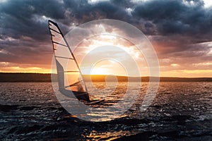 Windsurfing on a lake at sunset