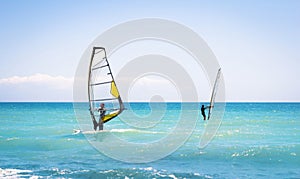 Windsurfing sails on the blue sea