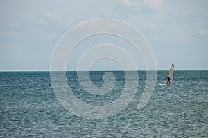 Windsurfing. Surfer exercising in calm sea or ocean