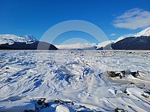 Windswept, snow covered mudflats, Turnagain Arm, outside of Girdwood, Alaska on a clear winter day.