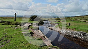 Windy post old stone cross next to stream on Dartmoor