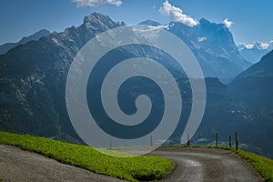 Windy road in Swiss Alps with majestic view on Wetterhorn peak