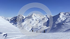 windy snowy mountianscape of view of skiers on a slope in val thorens france