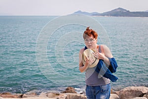 Windy summer days relaxing on coast feeling good. adult woman in glasses and jeans walks on the coast, portrays fright