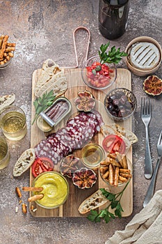 Wine apetizer set with salami, cheesem tomato, bread and alioli dip