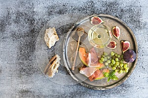 Wine appetizer set. Glass of white wine, honeycomb