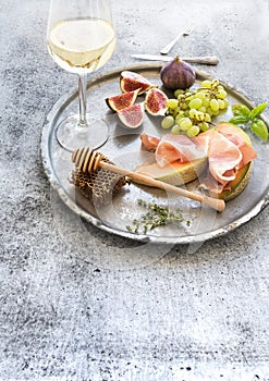 Wine appetizer set. Glass of white wine, honeycomb