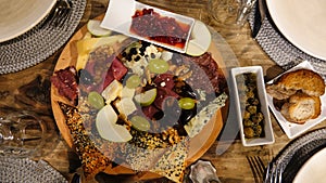 Wine appetizers; cheese, salami, sausage, dried meat, olives, grapes, bread, red sweet pepper sauce, sliced apples, empty plates o