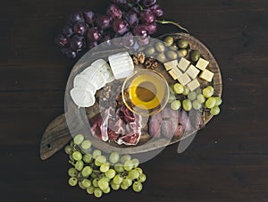 Wine appetizers set: meat and cheese selection, honey, grapes, w
