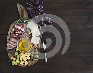 Wine appetizers set: meat and cheese selection, honey, grapes