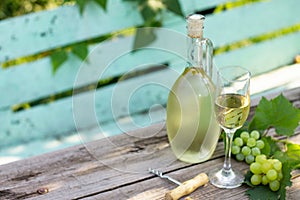 Wine background, wine concept. White wine bottles on wooden table. Outdoor still life in the vineyard.