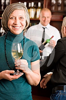 Wine bar senior woman barman discussing photo