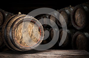 Wine barrel on the old wooden table. Wine cellar at the background