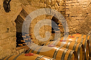 Wine barrels and bottles in a traditional cellar