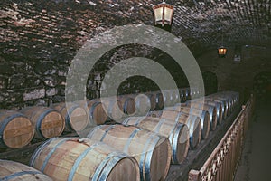 Wine barrels in a old cellar at winery. Wooden barrels of wine in vineyard.