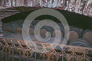 Wine barrels in a old cellar at winery. Wooden barrels of wine in vineyard.