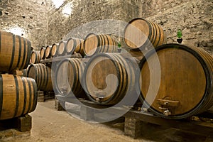 Wine barrels stacked in the old cellar of the winery,