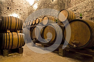 Wine barrels stacked in the old cellar of the winery. photo