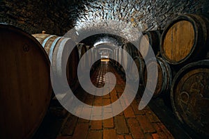 Wine barrels in a wine cellar. Small production. Underground tunnel. Storage of finished products. deep sharpness on a wide angle