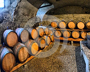 Wine barrels in wine-vaults in order. Wine barrels stacked in the old cellar
