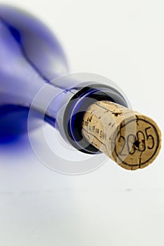 Blue bottle wine with a cork isolated on white bac