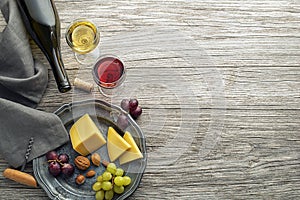 Wine bootle and glass with food on wooden table