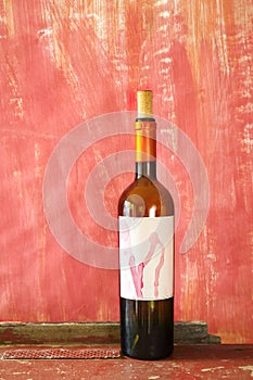 Wine bottle with blank label,  free copy space, grungy red background. Wine, winetasting, wine season mock up