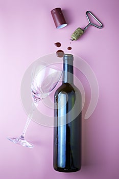 wine bottle cork corkscrew shrink wrap glass and drops of red wine on pink background